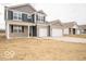 Charming two-story home featuring a brick facade, gray siding, attached two-car garage, and front porch at 6039 Granby Dr, Whitestown, IN 46075