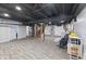 Unfinished basement with new flooring, painted ceiling, and laundry area at 6471 Homestead Dr, Indianapolis, IN 46227