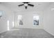 Bright bedroom with grey carpet, ceiling fan, and two large windows at 730 Sanders St, Indianapolis, IN 46203