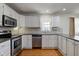 Efficient kitchen layout with stainless steel appliances, white cabinets, and ample counter space, perfect for cooking at 8116 E 900 N, Wilkinson, IN 46186