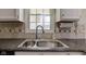 A modern kitchen sink, featuring a stainless steel finish, complemented by sleek countertops and a window view at 8116 E 900 N, Wilkinson, IN 46186