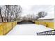 Snowy backyard with a black wrought iron gate and wooden fence at 1306 E Minnesota St, Indianapolis, IN 46203