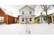 Two-story white house with pink door and walkway, snow on the ground at 1306 E Minnesota St, Indianapolis, IN 46203