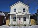 Two-story white house with pink door, covered porch, and snow-covered yard at 1306 E Minnesota St, Indianapolis, IN 46203