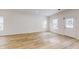 Living room with hardwood floors, white walls, and a door at 1306 E Minnesota St, Indianapolis, IN 46203