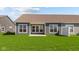 Back exterior view of a single Gathering home, featuring a lush green lawn, and concrete patio at 16673 Cattle Hollow Ln, Noblesville, IN 46060