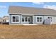 Backyard view of a home with blue siding and multiple windows, featuring a small patio and a grassy lawn at 16673 Cattle Hollow Ln, Noblesville, IN 46060