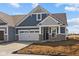 Charming blue home featuring stone accents, a two-car garage, and impeccable architectural details at 16673 Cattle Hollow Ln, Noblesville, IN 46060