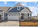 Beautiful blue home showcasing stone details, a spacious two-car garage, and stylish architectural design at 16673 Cattle Hollow Ln, Noblesville, IN 46060