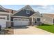 Inviting home with a two-car garage, well-maintained lawn, and stone accents on the facade at 16673 Cattle Hollow Ln, Noblesville, IN 46060