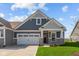 Charming single Gathering home featuring a two-car garage, manicured lawn and stone-accented facade at 16673 Cattle Hollow Ln, Noblesville, IN 46060