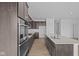 Contemporary kitchen with an island, dark cabinets, stainless steel appliances, and wood-look flooring at 16673 Cattle Hollow Ln, Noblesville, IN 46060