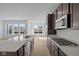 Open concept kitchen with island, stainless steel appliances, dark cabinets, and abundant natural light at 16673 Cattle Hollow Ln, Noblesville, IN 46060