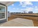 Concrete patio looking out towards new construction homes and open grassy spaces on a beautiful day with blue skies at 16673 Cattle Hollow Ln, Noblesville, IN 46060