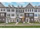 Three-story townhouses with brick and siding exteriors,landscaped yards, and inviting walkways at 1836 Blenker Dr, Carmel, IN 46032