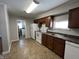 Kitchen with brown cabinets, white appliances, and tile floor at 2116 N Rosewood Ave, Muncie, IN 47304