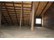 Unfinished attic space with wood framing and window at 3469 N Capitol Ave, Indianapolis, IN 46208