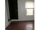 Simple bedroom with wood floors and window at 3469 N Capitol Ave, Indianapolis, IN 46208