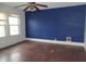 Bedroom with blue accent wall, wood floors, and ceiling fan at 3469 N Capitol Ave, Indianapolis, IN 46208