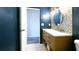 Stylish bathroom with herringbone accent wall, modern vanity and door to hall at 4351 Village Parkway W Cir # 5, Indianapolis, IN 46254