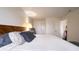 Bedroom with neutral walls and hardwood floors, featuring a large bed with striped bedding and soft pillows at 4351 Village Parkway W Cir # 5, Indianapolis, IN 46254
