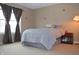Cozy bedroom with gray bedding and window curtains at 504 Grand Woods Dr, Indianapolis, IN 46224