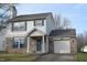 Two-story house with vinyl siding, brick skirt, attached garage, and front yard at 504 Grand Woods Dr, Indianapolis, IN 46224
