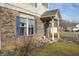 Brick entryway with a covered porch, blue door and landscaping at 504 Grand Woods Dr, Indianapolis, IN 46224