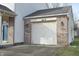 Attached one-car garage with white door and brick facade at 504 Grand Woods Dr, Indianapolis, IN 46224