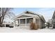 Gray bungalow with a covered porch, snowy front yard, and well-maintained landscaping at 5116 E St Clair E St, Indianapolis, IN 46219