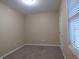 Simple carpeted bedroom with a window and door at 513 N Park Ave, Indianapolis, IN 46202