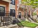 Exterior view showcasing brick facade, black railings, and blooming trees, leading to the front door at 6595 Reserve Dr, Indianapolis, IN 46220
