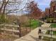A walking path winds through the community near a wooden fence and mature trees that offers serene views of the creek at 6595 Reserve Dr, Indianapolis, IN 46220