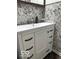 White bathroom vanity with black hardware and gray leaf wallpaper at 81 Middleton Rd, Franklin, IN 46131