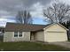 Beige house with stone accents, brown roof, and attached garage at 9120 Jene Ct, Indianapolis, IN 46234