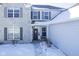 Front entrance with stone facade, gray door, and snowy walkway at 10963 Field Crescent Cir, Noblesville, IN 46060