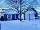 Brick ranch home with attached garage, snow-covered yard, and mature trees at 12306 Split Granite Dr, Fishers, IN 46037