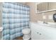 Bathroom with white vanity, shower, and blue striped curtain at 1704 Nelson Ave, Indianapolis, IN 46203