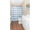 Bathroom with white vanity, shower, and blue striped curtain at 1704 Nelson Ave, Indianapolis, IN 46203