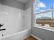 Bright bathroom with tub-shower combo and a window at 1705 Real St, Indianapolis, IN 46240