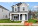 Charming two-story home featuring a covered porch, blue siding, and a well-maintained lawn at 1705 Real St, Indianapolis, IN 46240