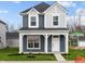 Charming two-story home featuring a covered porch, blue siding, and a well-maintained lawn at 1705 Real St, Indianapolis, IN 46240