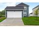 A two-car garage and well-manicured lawn highlight the property's inviting exterior at 1705 Real St, Indianapolis, IN 46240