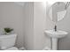 Contemporary powder room with a pedestal sink, mirror, and toilet at 1705 Real St, Indianapolis, IN 46240