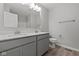 Bathroom showcasing a double vanity with gray cabinetry, quartz counters, and framed mirror at 1709 Real St, Indianapolis, IN 46240
