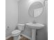 Stylish half-bathroom featuring wood-look floors, pedestal sink, and toilet at 1709 Real St, Indianapolis, IN 46240