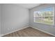 This bedroom features luxury vinyl plank flooring, a window, and neutral paint at 1709 Real St, Indianapolis, IN 46240