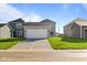 New construction home has a spacious two-car garage with a concrete driveway surrounded by green lawns at 1709 Real St, Indianapolis, IN 46240