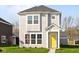 Charming two-story home with light gray siding, white trim, bright yellow door and manicured lawn at 1709 Real St, Indianapolis, IN 46240