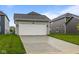 A two-car garage with a paved driveway and a manicured lawn at 1709 Real St, Indianapolis, IN 46240